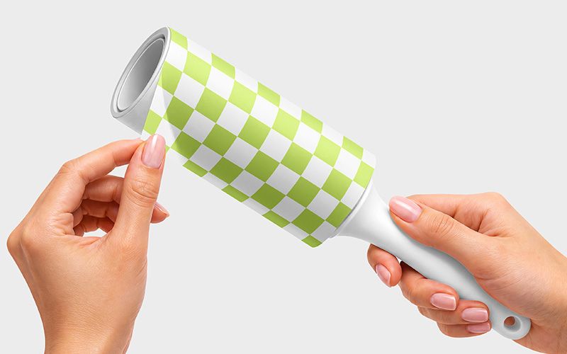 Lint roller mockup with a white handle and a lime green and white checkerboard wrapper held in two hands