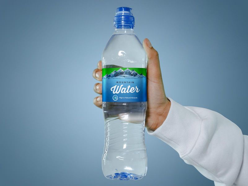 Free Hand Holding Water Bottle Label Mockup PSD
