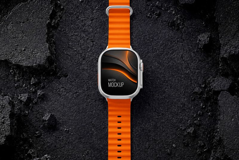 Top view rugged smartwatch mockup with orange strap on dark stone background for fitness app screen and watch face presentation.