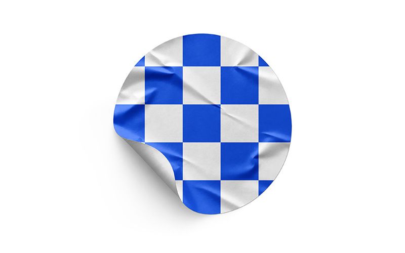 Wrinkled round sticker mockup with a blue and white checkerboard design and curled edge on a white background