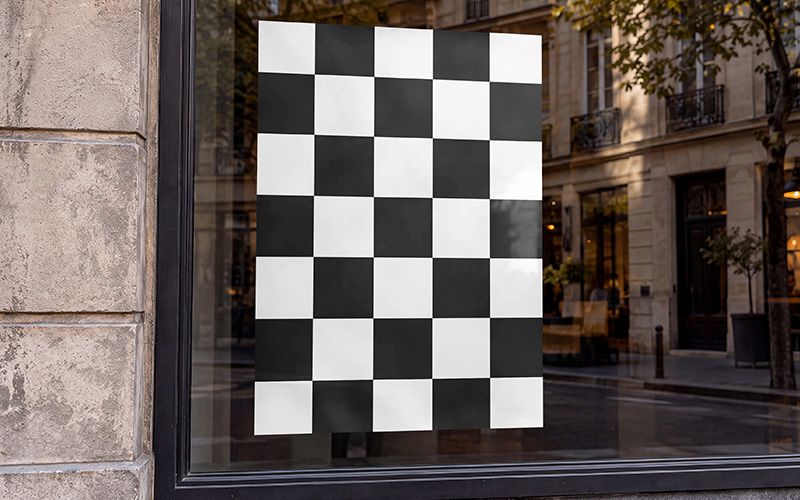 Shop window poster mockup with a black and white checkerboard poster and street reflections