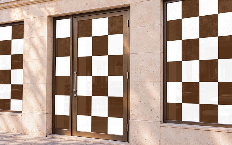 Restaurant window mockup with brown and white checkerboard artwork across the storefront windows and glass entrance door