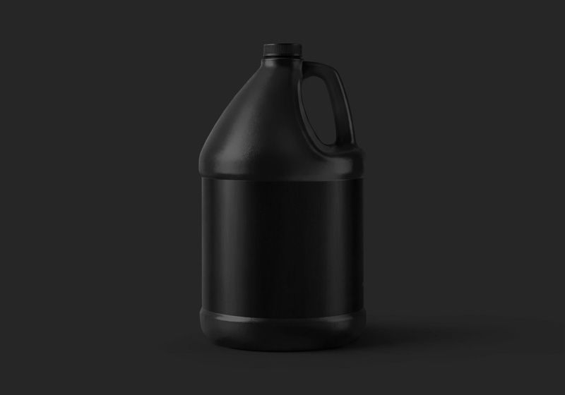 Black 1 gallon plastic jug mockup with a blank black label on a dark background