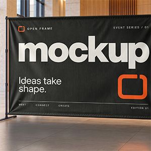 Freestanding black event backdrop with cream lettering and orange graphics in a modern venue lobby